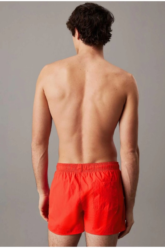 Calvin Klein ανδρικό μαγιό short σε κόκκινο χρώμα με το λογότυπο της εταιρίας στο πλάι KM0KM01100-XM8